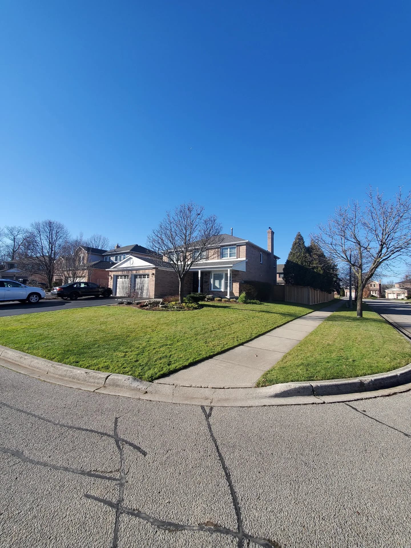 After fall yard clean up in Hamilton with a leaf-free lawn, clean sidewalk, and sharp edging on a corner lot