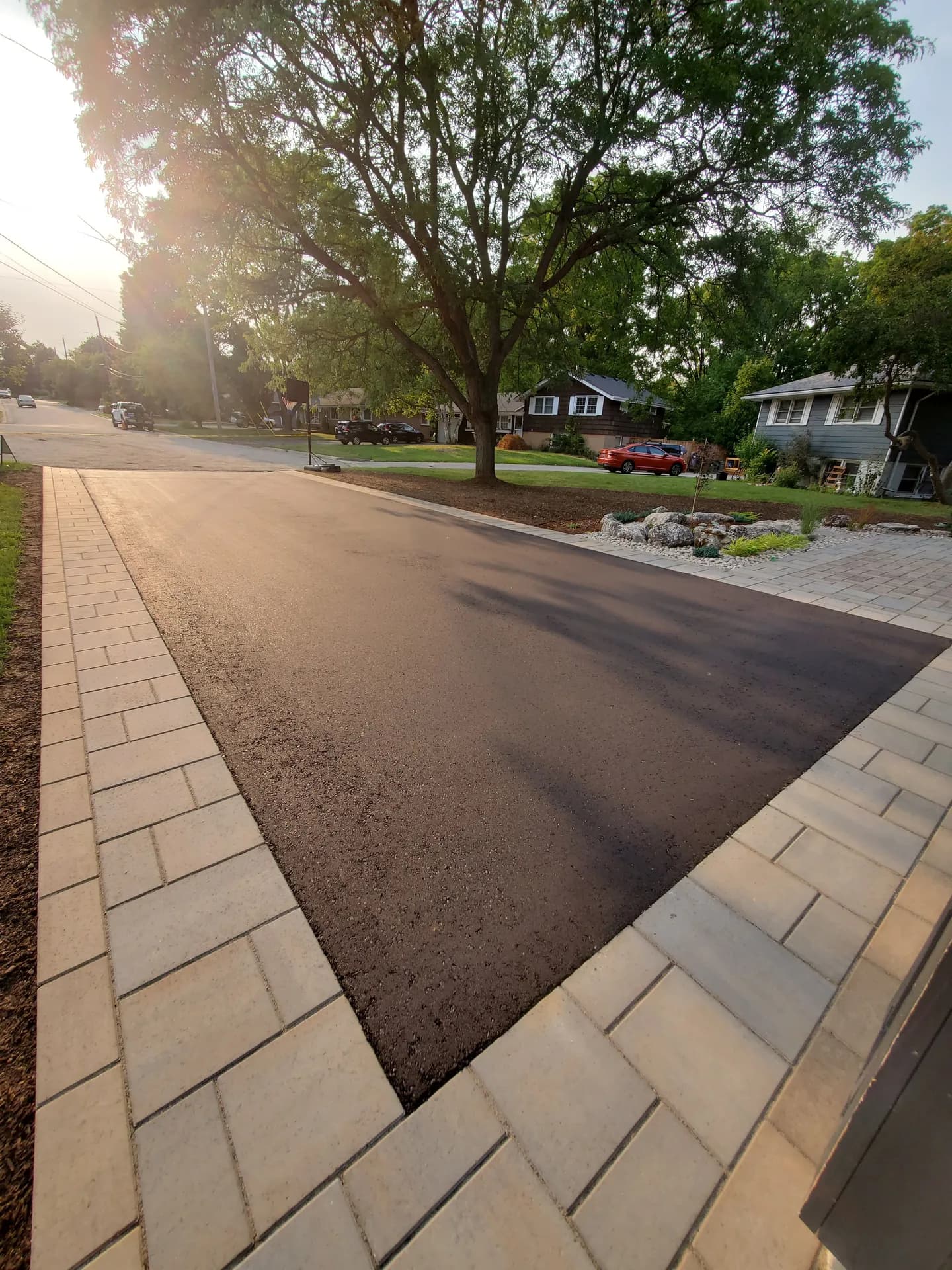 Interlock driveway border framing fresh asphalt at a suburban home in Hamilton, Ontario