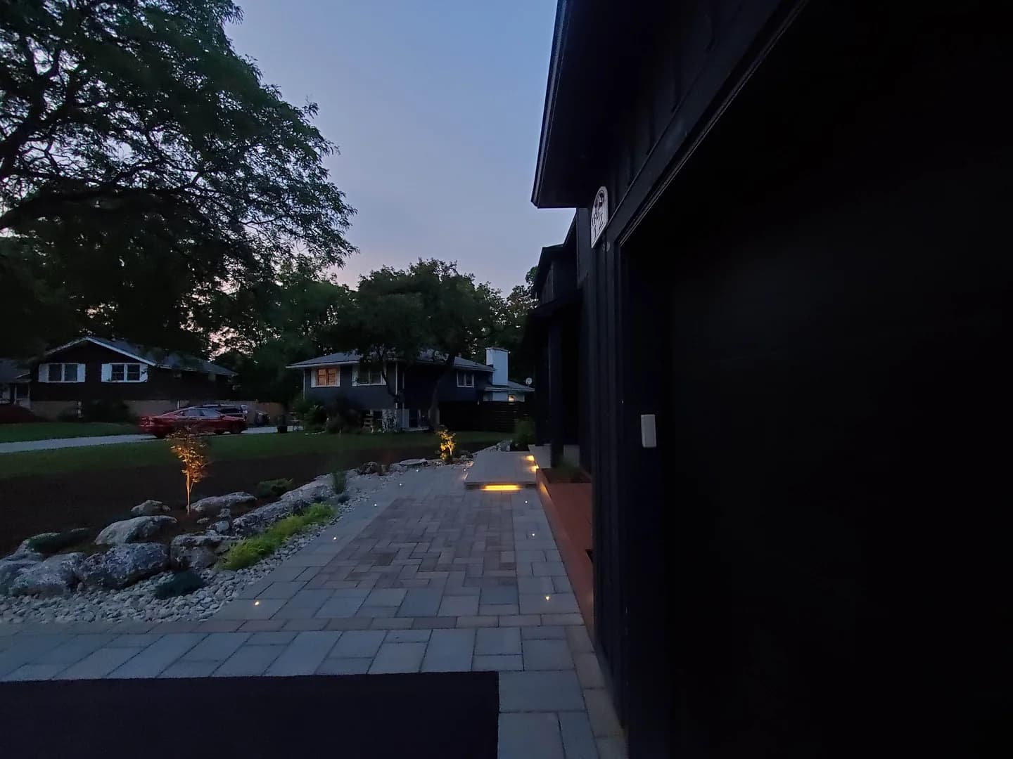 Low-voltage paver path and step lights along a front walkway at dusk on a Burlington landscaping project